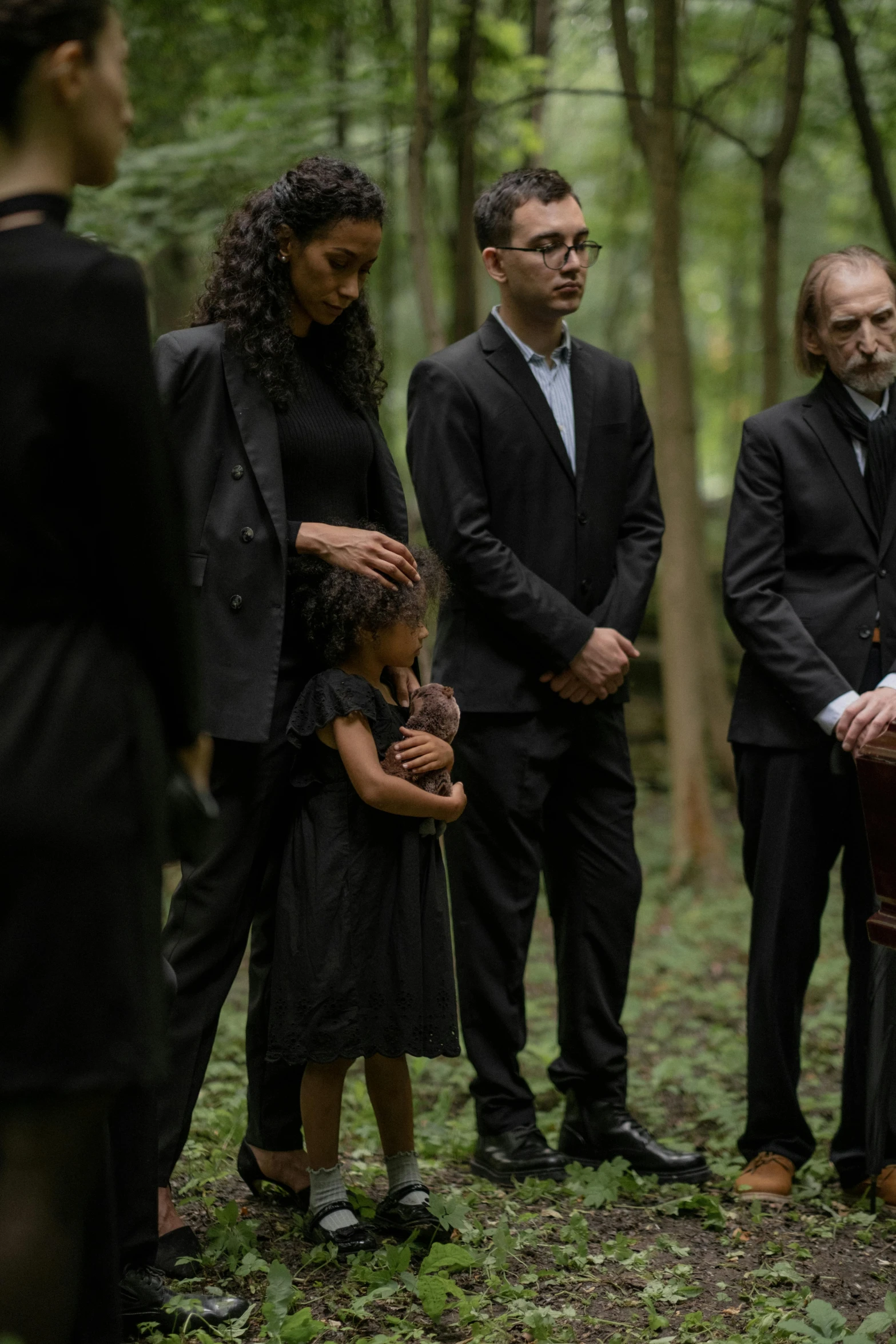 the family stands in the forest with the  looking on