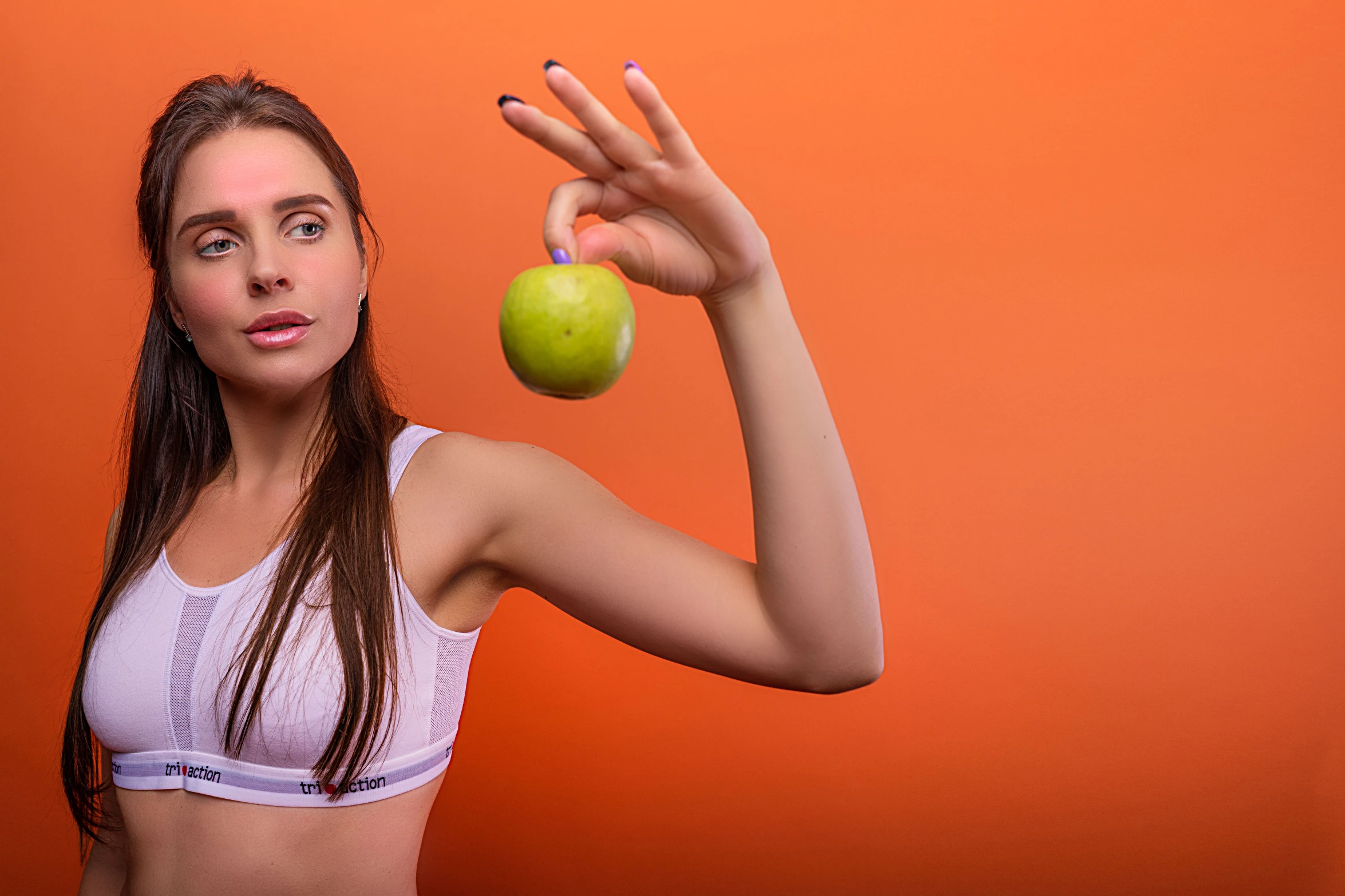 there is a girl holding an apple and a tennis ball