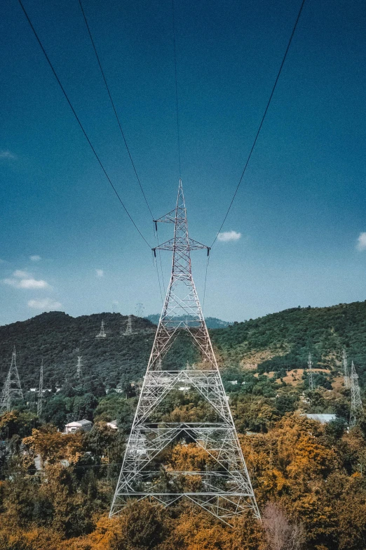 an overhead view of power lines crossing over a hillside