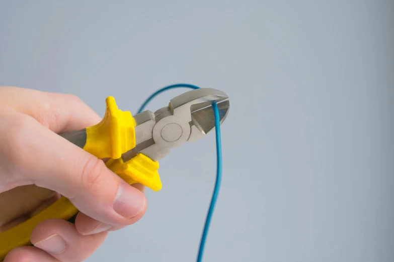 a person is using scissors to cut yellow paper