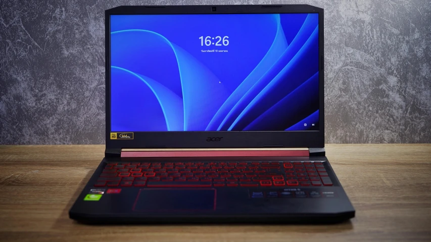 a laptop computer with a red keyboard on a wooden surface