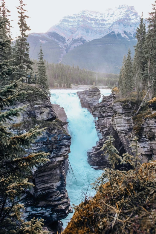 a view from above of a mountain river that has blue colored water