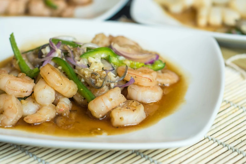 a white plate topped with rice and shrimp