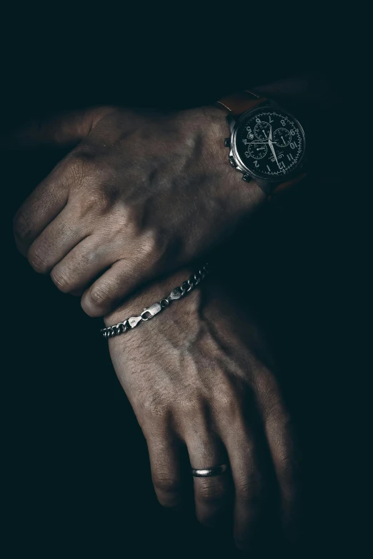 a man is wearing some jewelry on his wrist