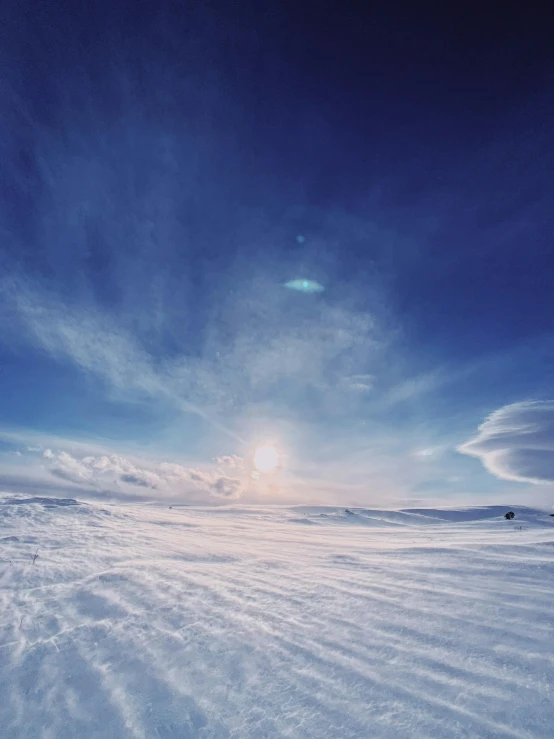a snow covered ground under a blue sky