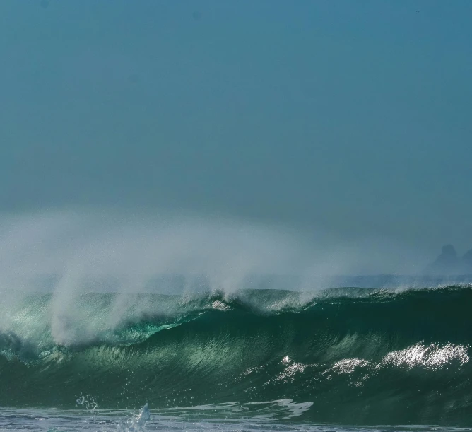 a man riding the crest of a big wave