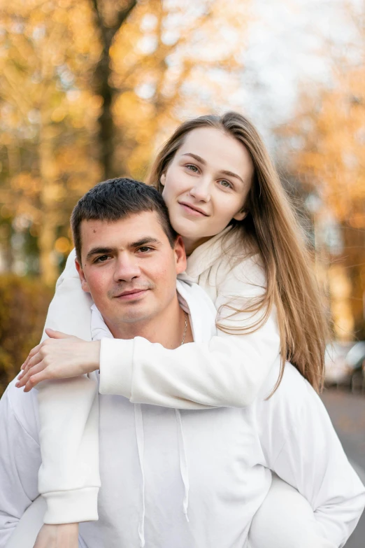 a man with long hair holds his girlfriend for a picture