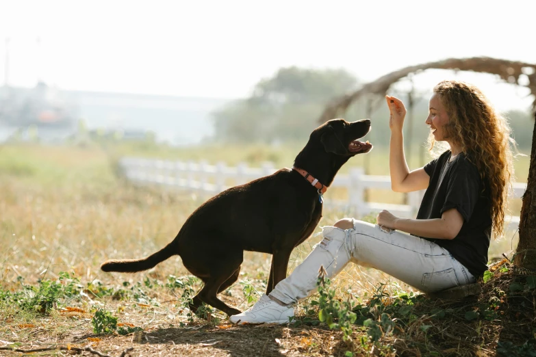 a woman and her dog look up at soing in the sky