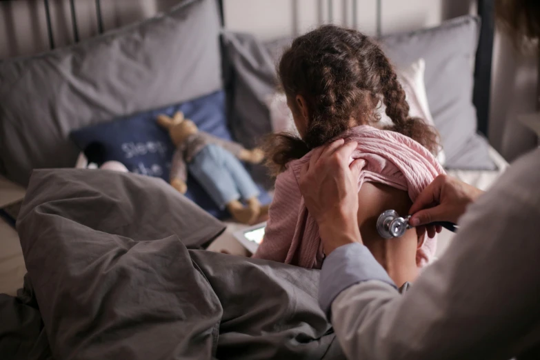 a little girl in a pink shirt is in bed with her parents