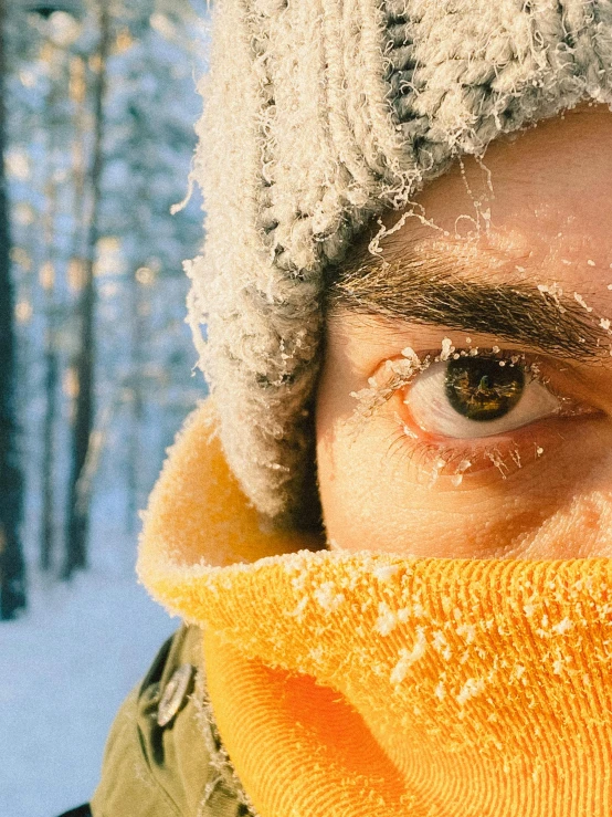 the man is bundled up and covering his face with a scarf