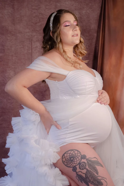 a pregnant woman in white with her  exposed