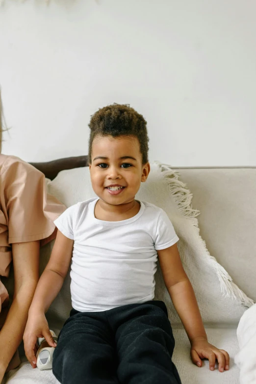 a little boy sitting on a couch next to an older woman