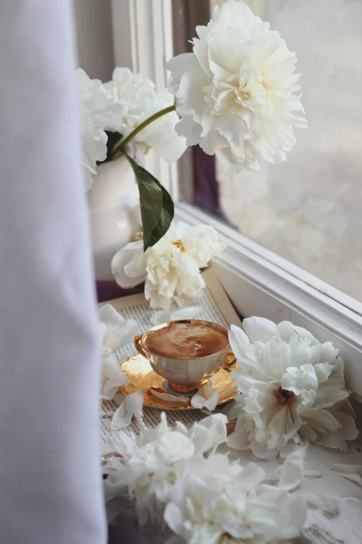 some white flowers and a cup on a table