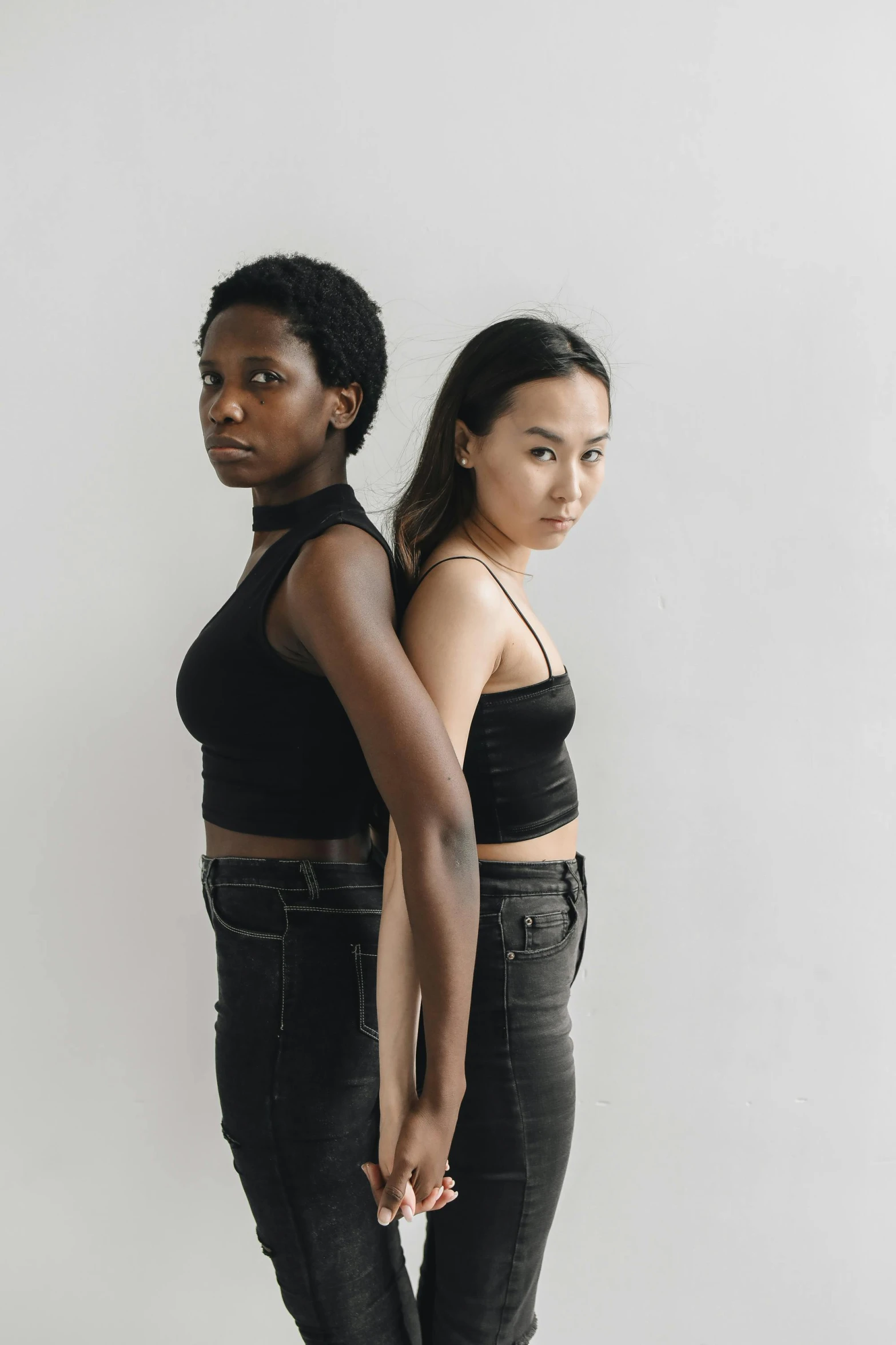 two woman standing side by side wearing black clothes