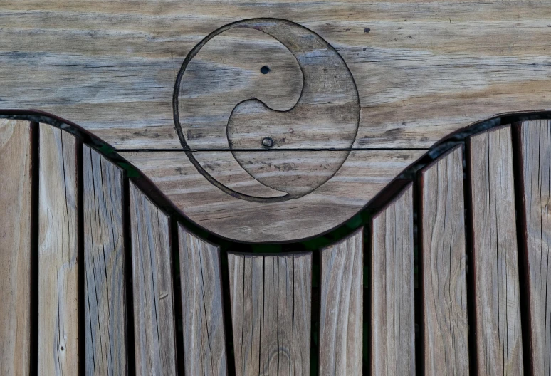 this is a detail of a wood bench that has the letter q engraved in it