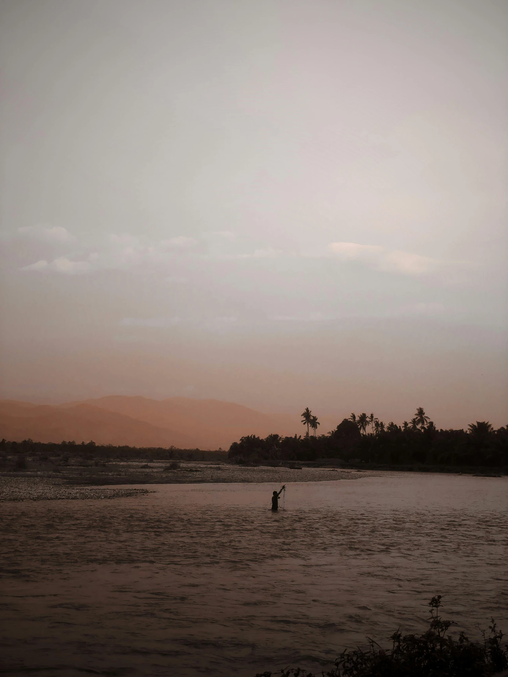 a person is riding a surfboard at sunset