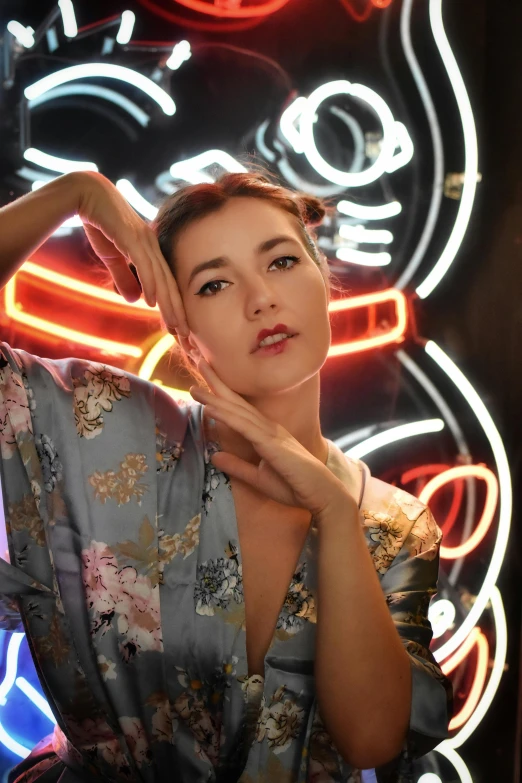 the woman is posing for the camera in front of neon lights