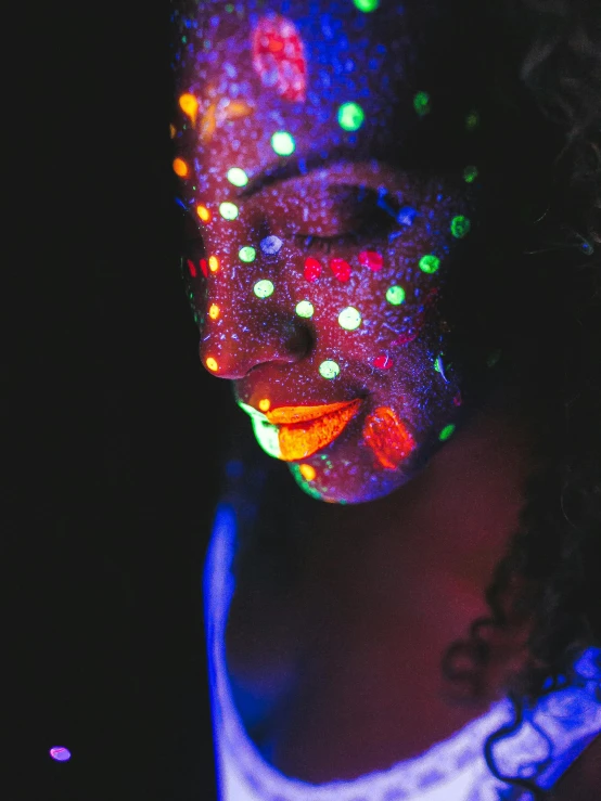 a woman with her face painted in a colorful paint