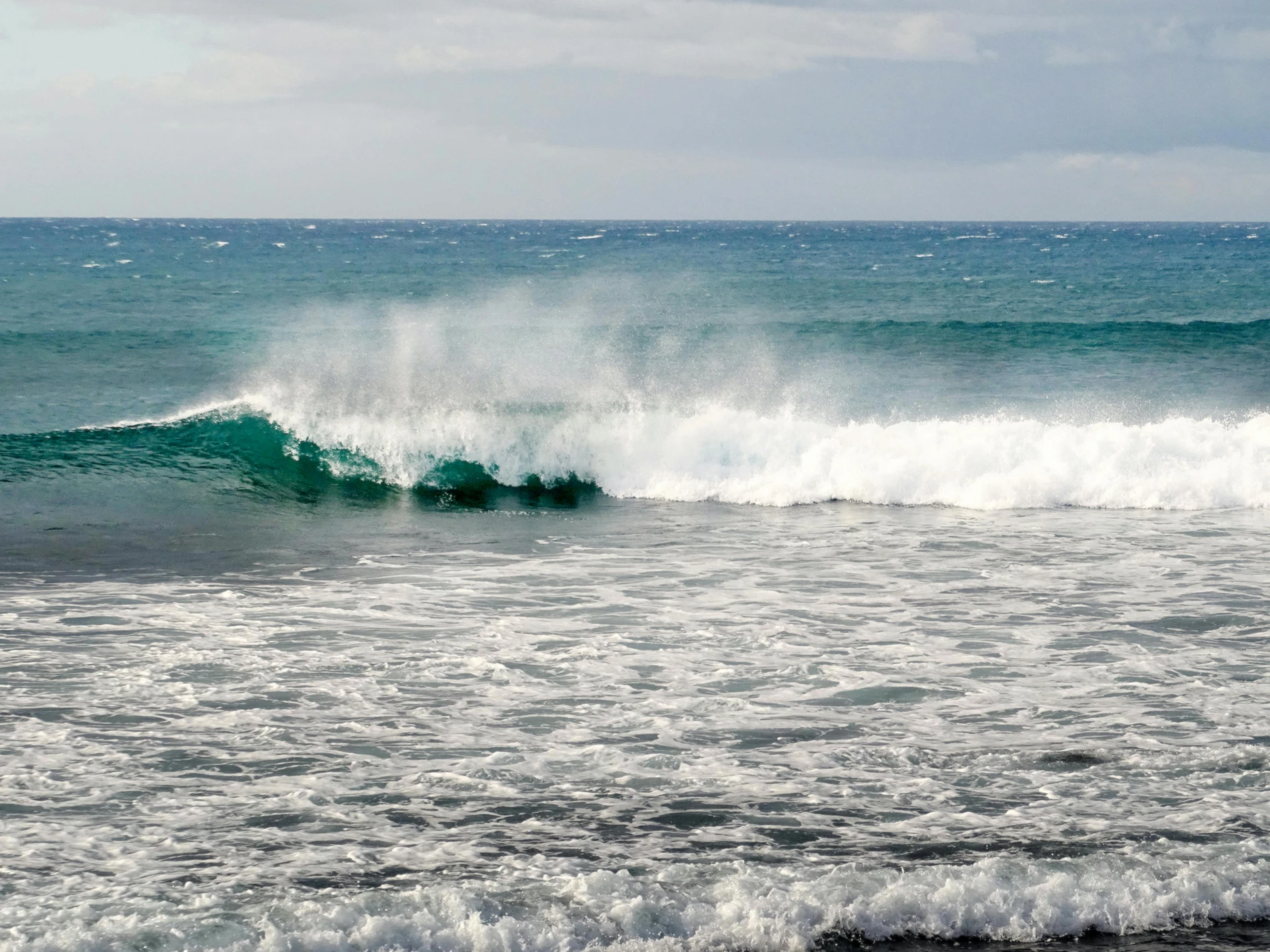 waves crash about the top of a breaking surf