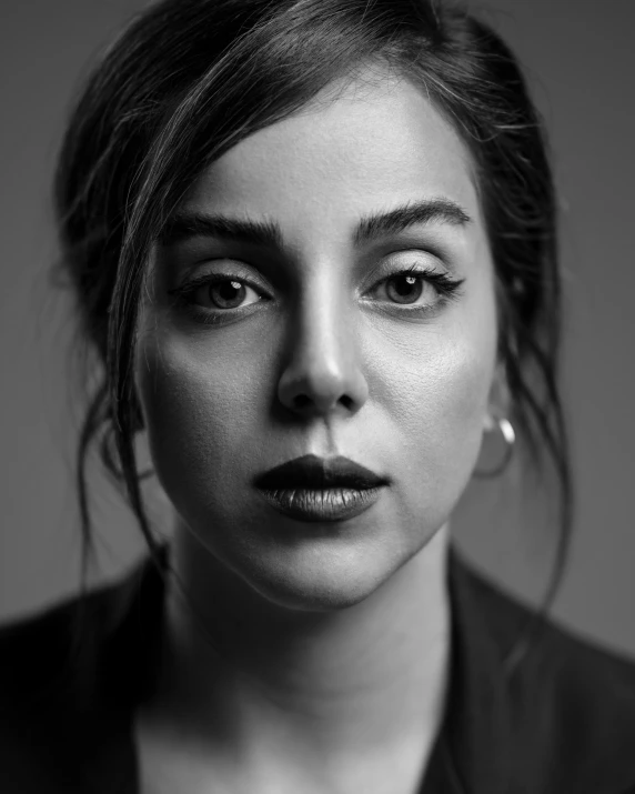 a woman with short hair and piercings is looking at the camera