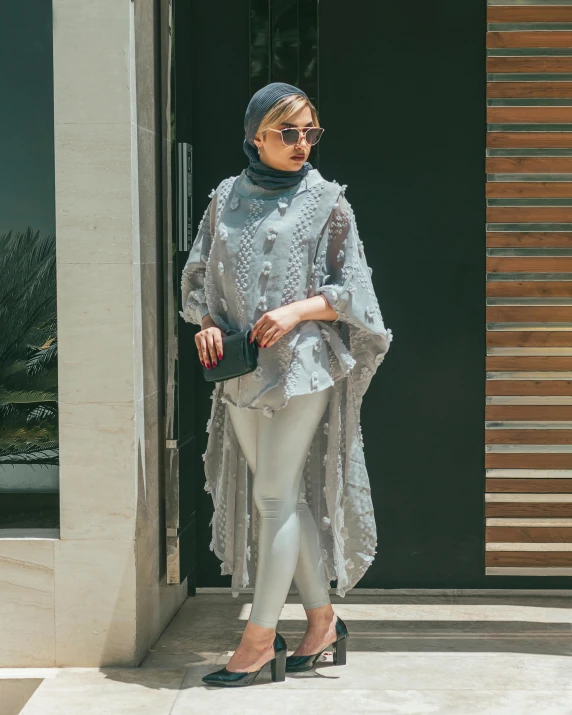 a woman in all white and a scarf on