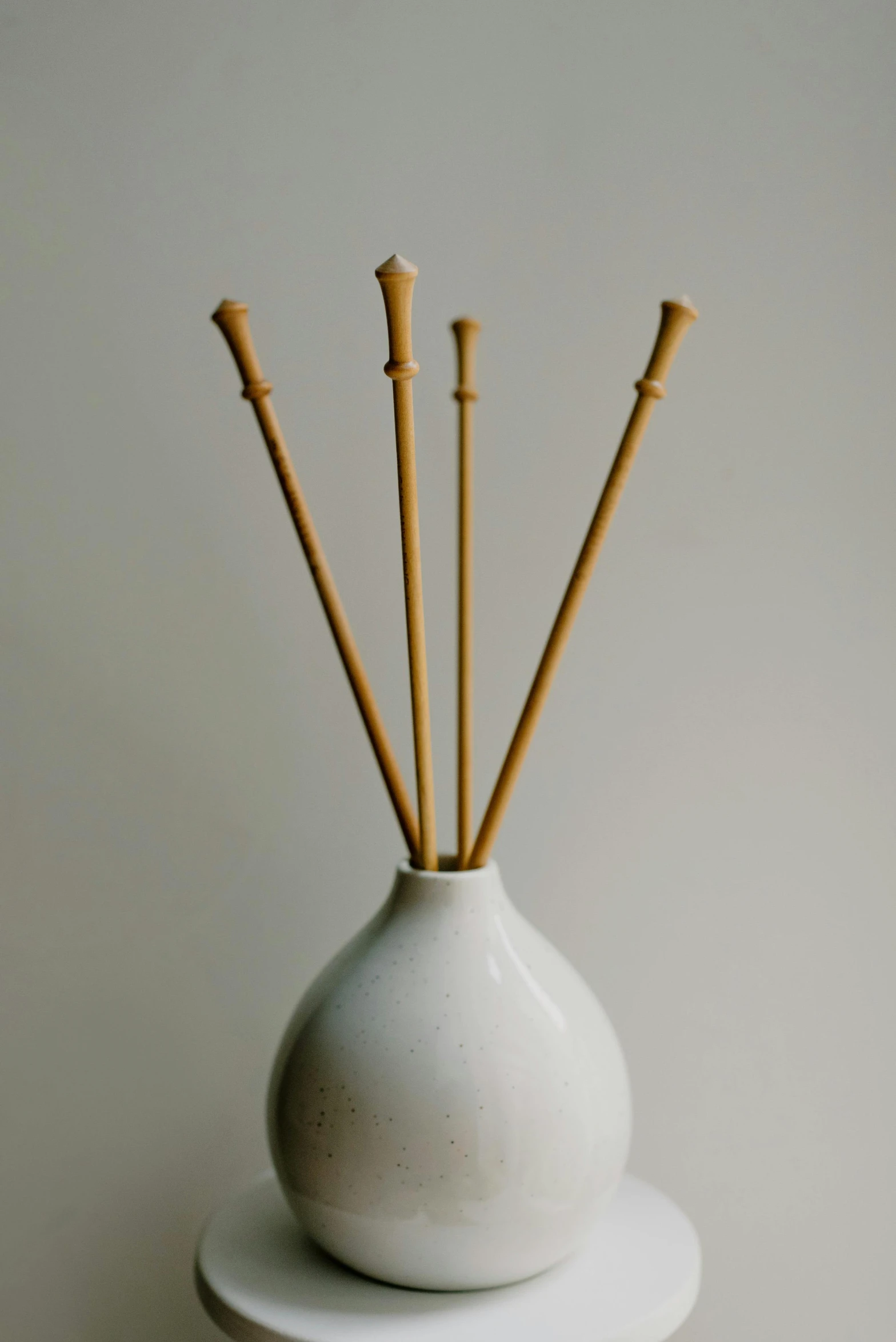 three small decorative wooden sticks in a vase