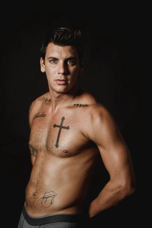 shirtless man with cross tattoos posing for a picture