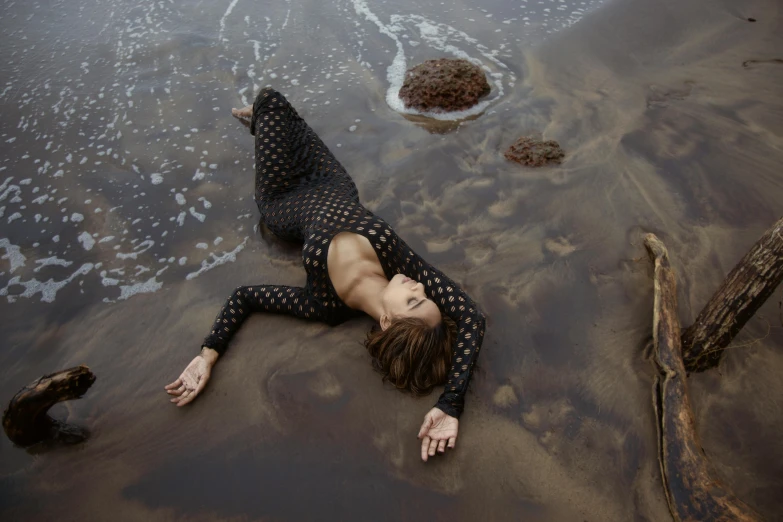 a girl laying on the beach while surfing