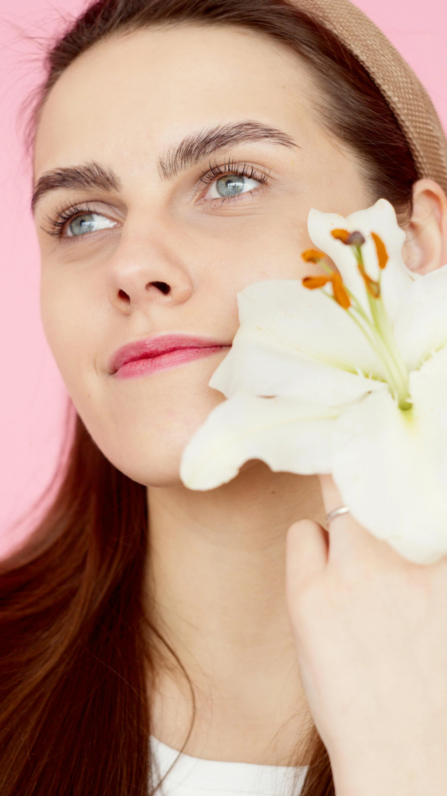 a woman is holding a white flower to her face