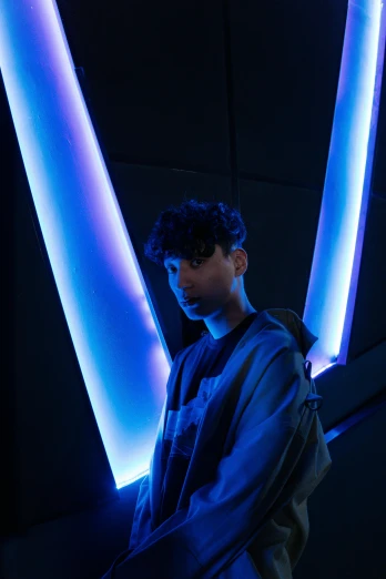 a man standing in a dark room with blue lighting
