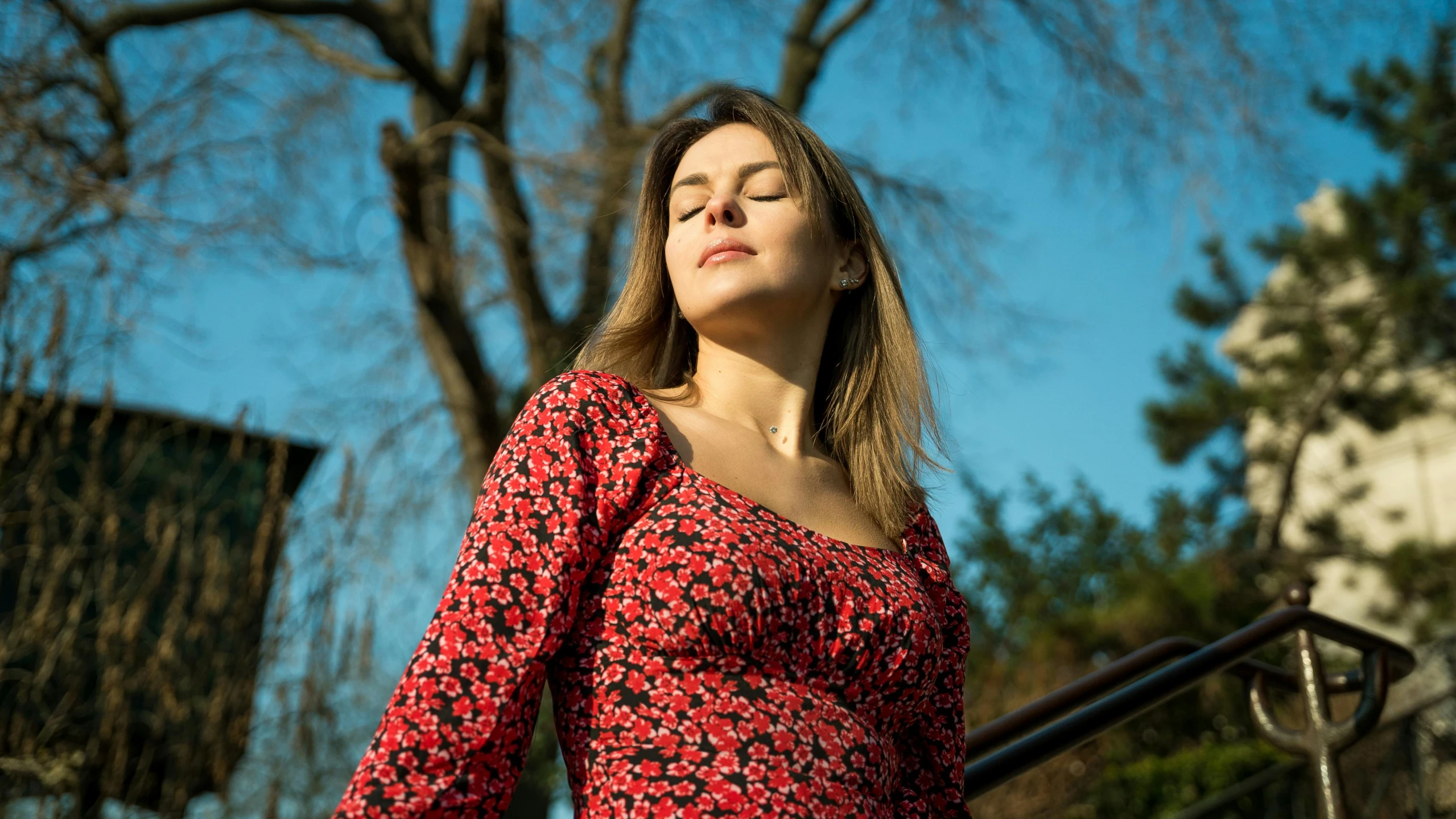 a woman wearing a red dress standing on some steps