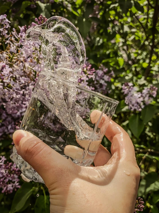 someone holding up a broken glass bottle in their hand