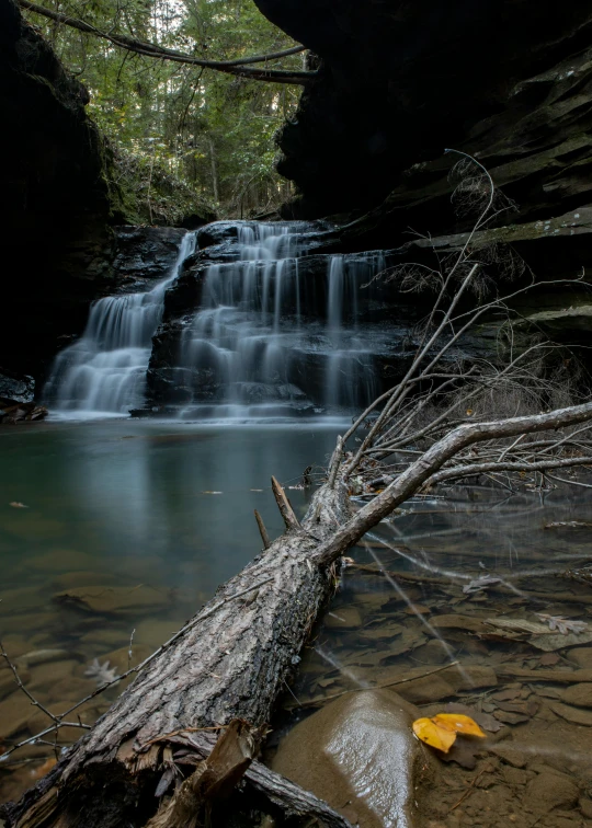 a waterfall is seen through some rocks and sticks