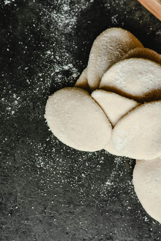 dough on a counter top next to wooden spoons