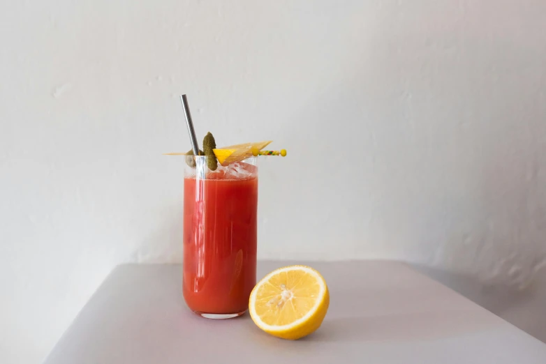 an orange half with two straws and an orange slice next to it