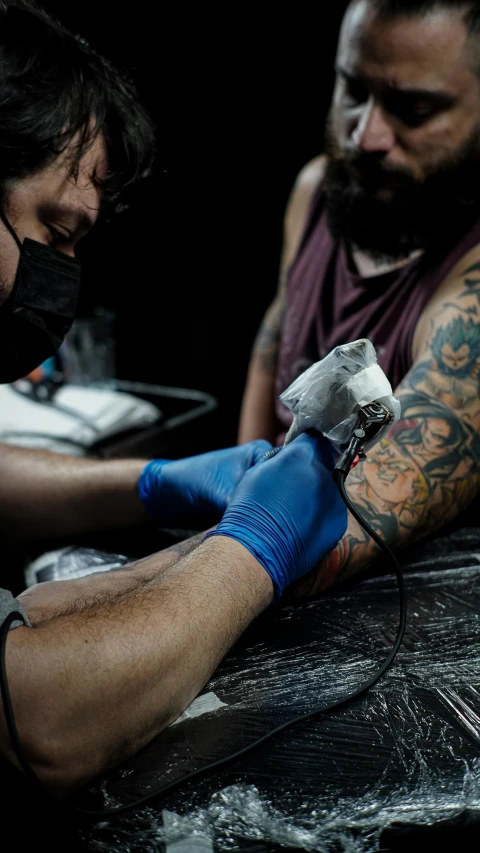 a couple of men are getting some tattoos