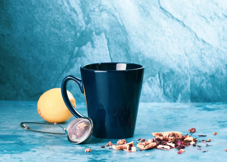 a bowl of grain next to a coffee cup and a spoon