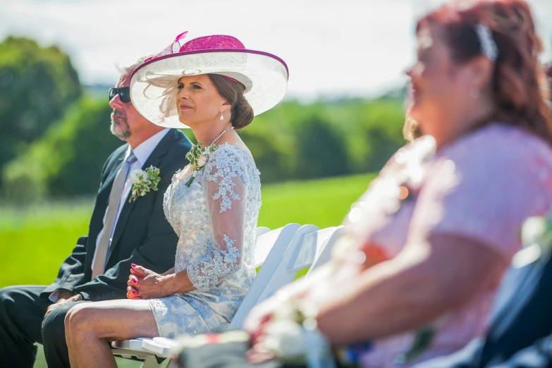 two people are wearing matching hats and sitting in chairs