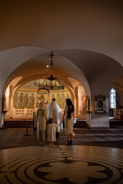 people at a large church in an area with circular tiles