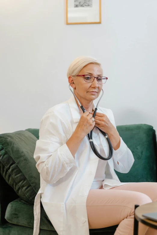 woman with white hair wearing glasses holding a stethoscope