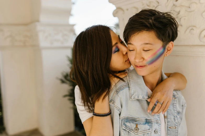 couple kissing while they are painted rainbow colors