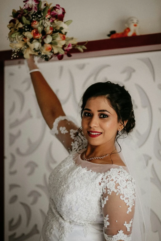 a bride in a wedding dress holding her bouquet in her hand