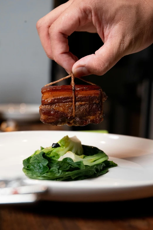 a person holds a piece of food that is on a plate