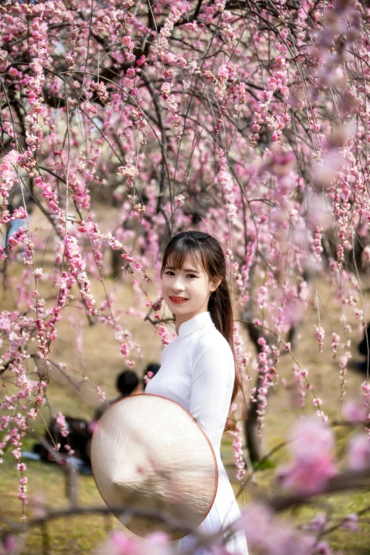 a woman standing in front of a blooming tree