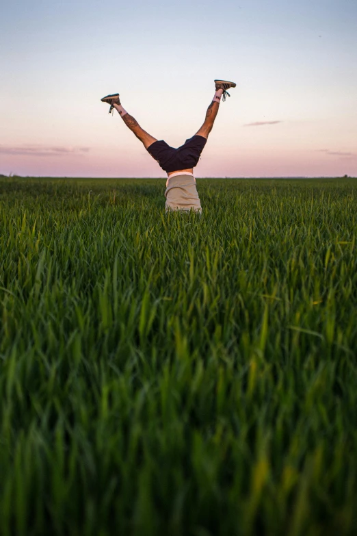 a person standing in a large field holding two baseball gloves