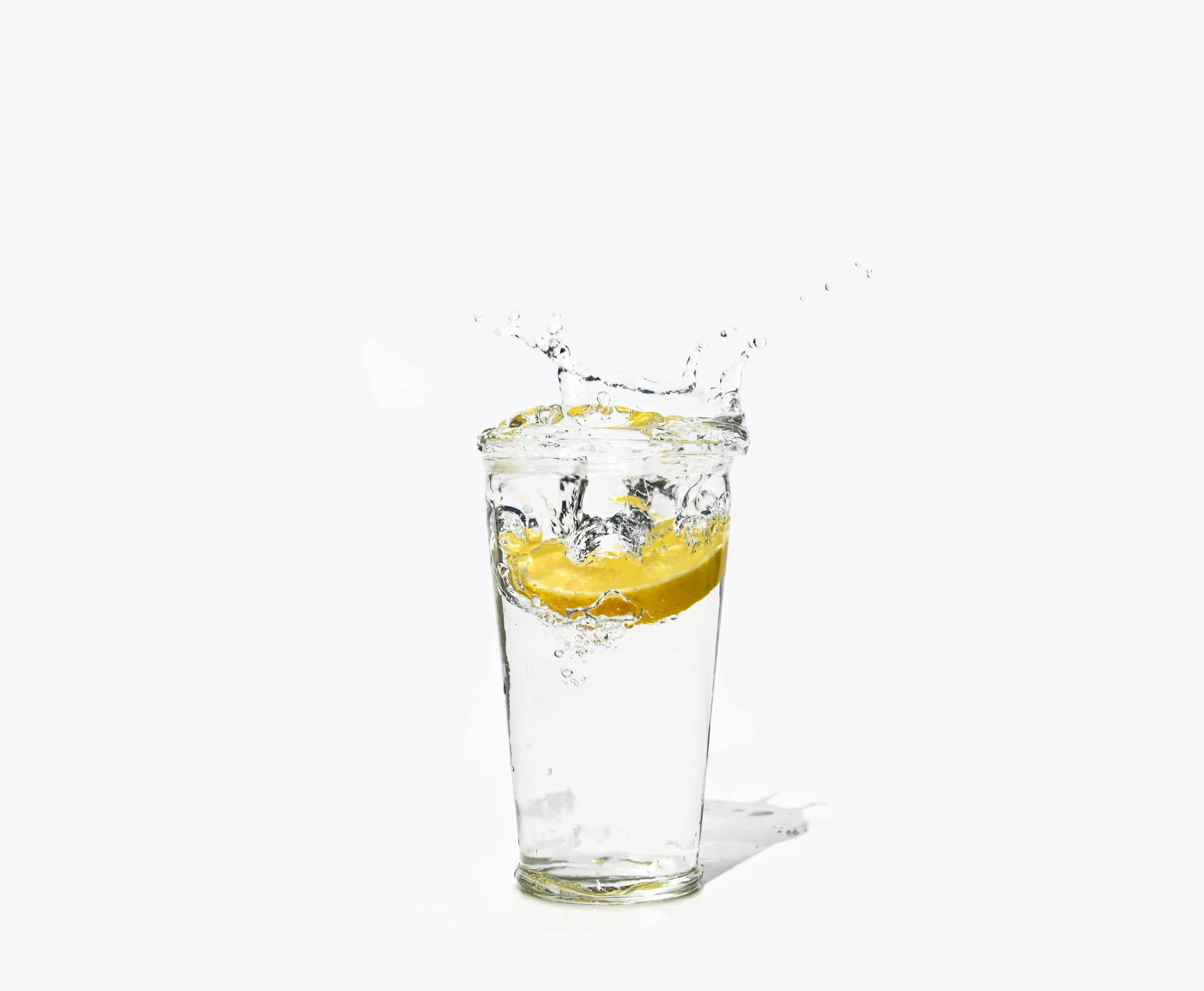 a clear glass full of yellow liquid and some water