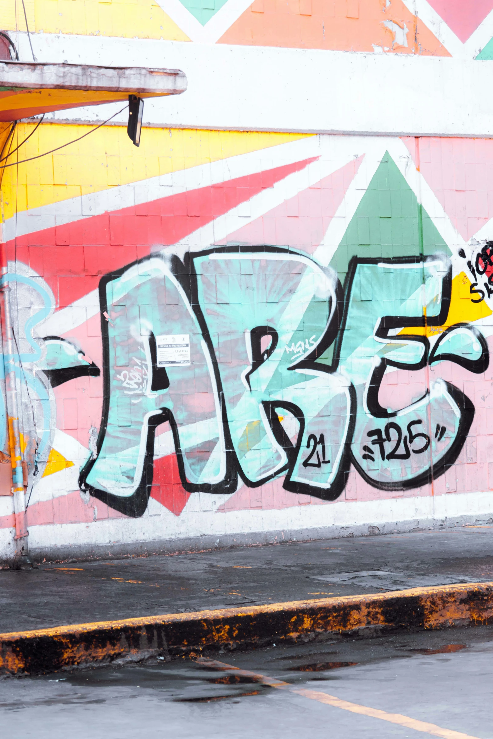 a person skates down a street in front of graffiti