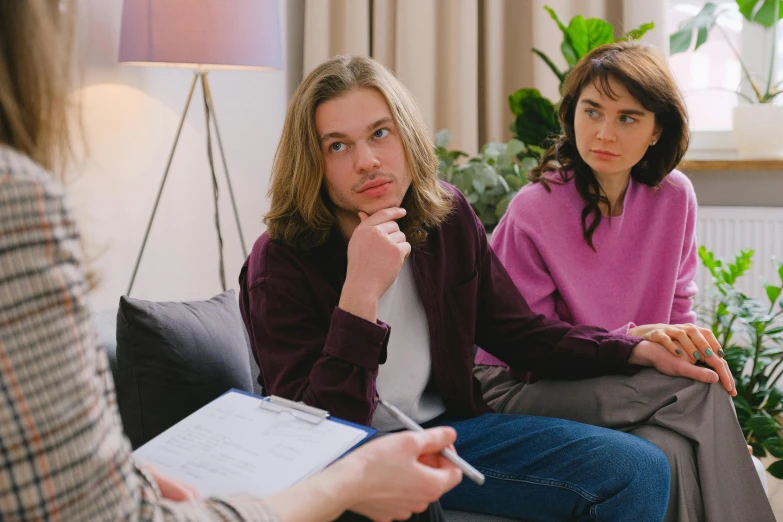 a woman sitting on top of a couch talking to another woman