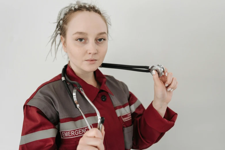 a girl in an emergency shirt is holding a stethoscope