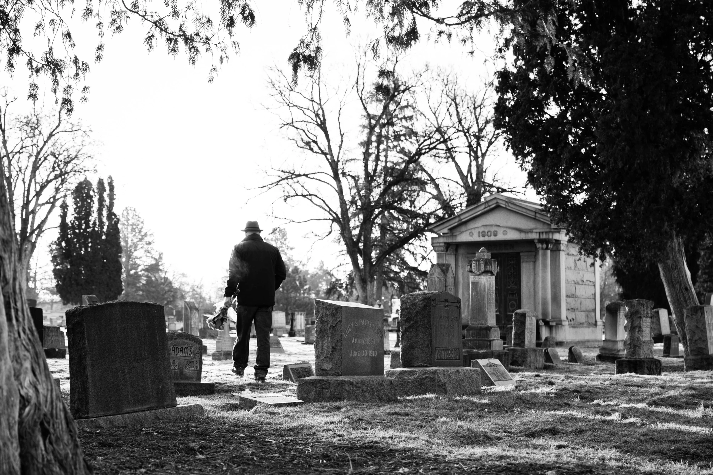 a man walking through a cemetery in the middle of nowhere